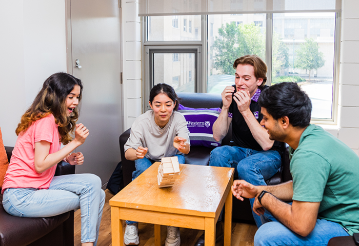 Four students sitting around a table playing a game