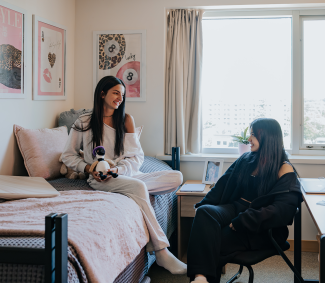 Two girls talking in their residence room